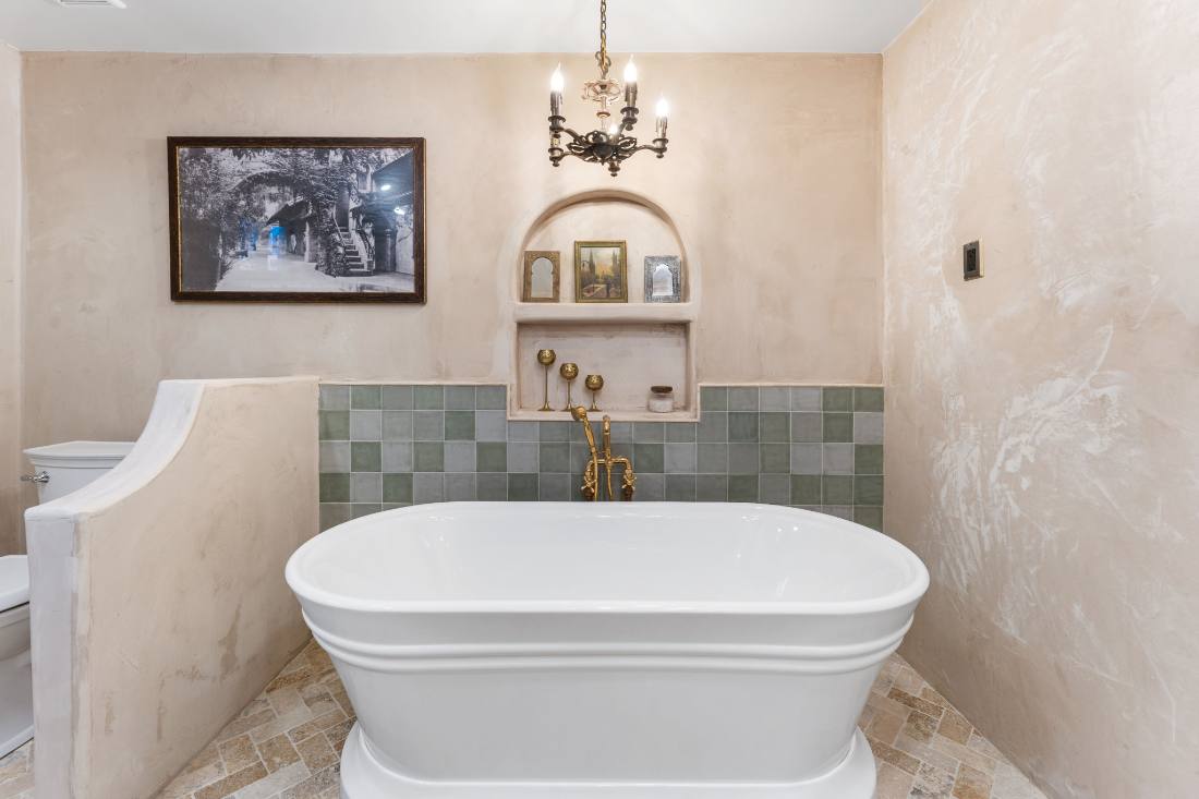 Plaster bath with sage tile and brass tub filler
